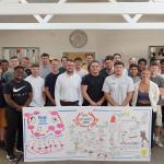 FBU young members gather around a banner with illustrations from discussions around the fire service 