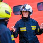 A firefighter talks to fellow women firefighters