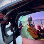 Firefighter wearing water goggles with rescue boat refected