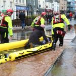 Firefighters towing a rescue boat in flood water